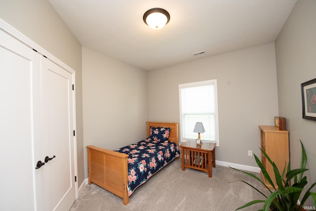 carpeted bedroom with baseboards and a closet