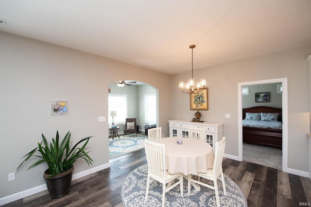 dining room with arched walkways, dark wood-type flooring, baseboards, and a chandelier