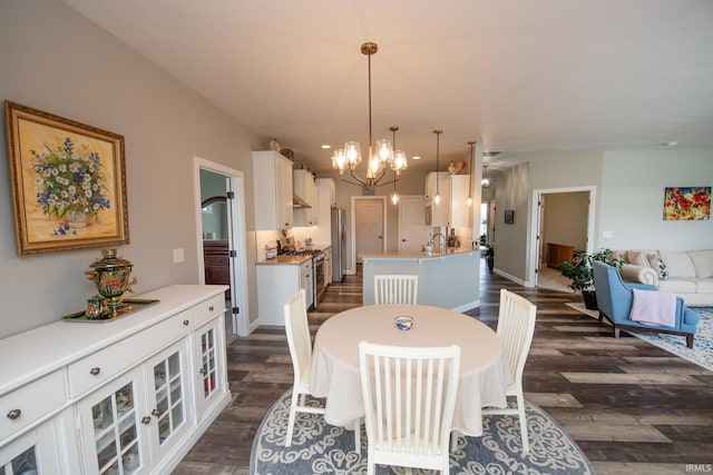 dining room featuring a chandelier, dark wood-style flooring, and baseboards