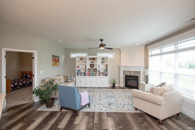 living area with a ceiling fan, dark wood-style flooring, and a tile fireplace