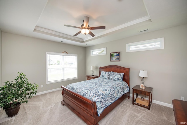 bedroom featuring a raised ceiling, carpet floors, ornamental molding, baseboards, and a ceiling fan