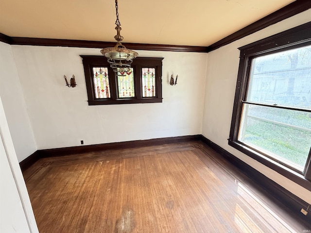 118 13th St, Logansport, IN 46947 - empty room featuring wood-type flooring, healthy amount of natural light, a chandelier, and baseboards
