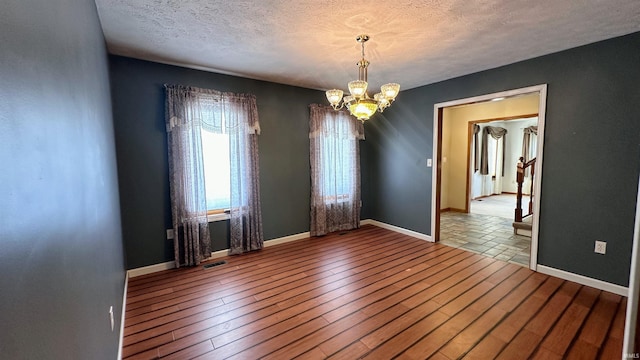 9081 N 725 E, Otterbein, IN 47970 - empty room featuring a chandelier, a textured ceiling, wood finished floors, and baseboards