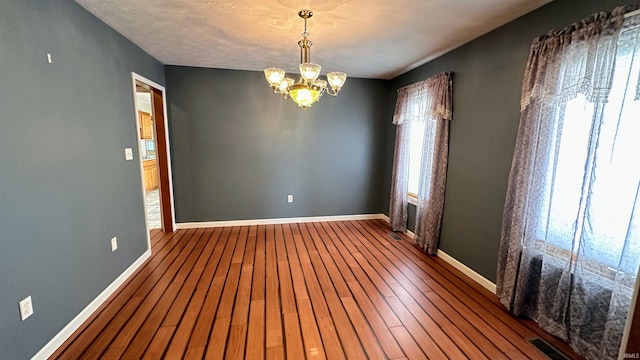 9081 N 725 E, Otterbein, IN 47970 - empty room featuring a chandelier, hardwood / wood-style flooring, and baseboards