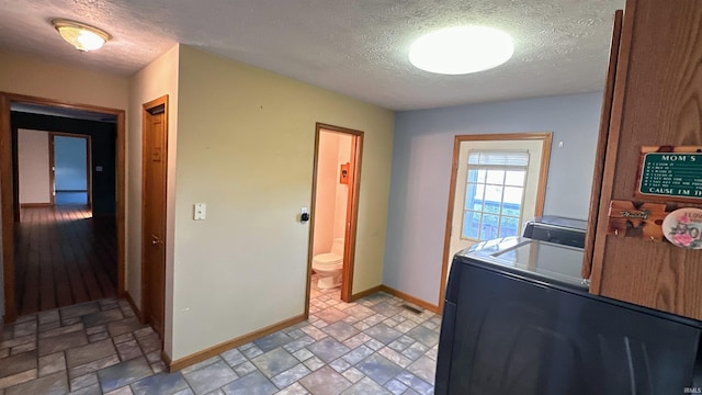 9081 N 725 E, Otterbein, IN 47970 - laundry room with stone finish flooring, a textured ceiling, baseboards, and washer and clothes dryer