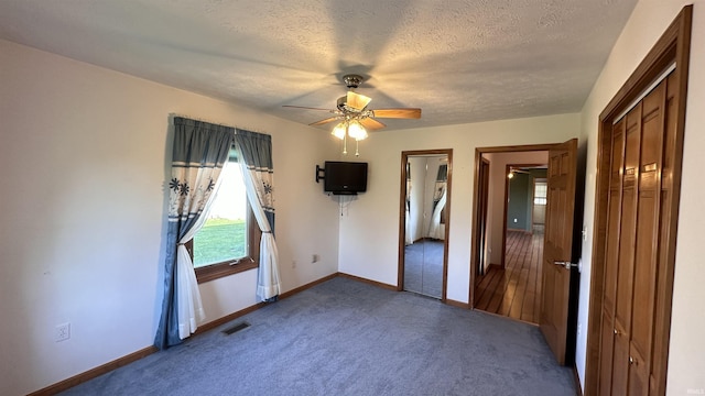 9081 N 725 E, Otterbein, IN 47970 - unfurnished bedroom featuring multiple windows, carpet floors, baseboards, a textured ceiling, and a ceiling fan