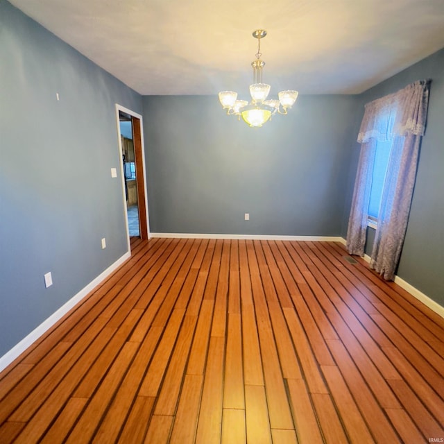 9081 N 725 E, Otterbein, IN 47970 - empty room featuring a chandelier, baseboards, and wood finished floors