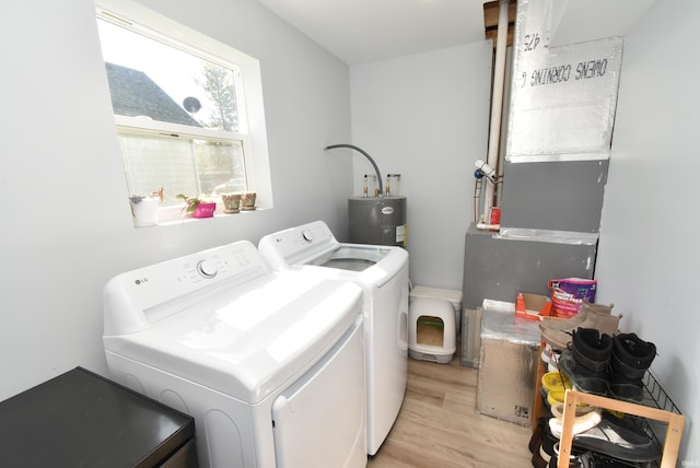 washroom with washer and dryer, water heater, and light wood finished floors