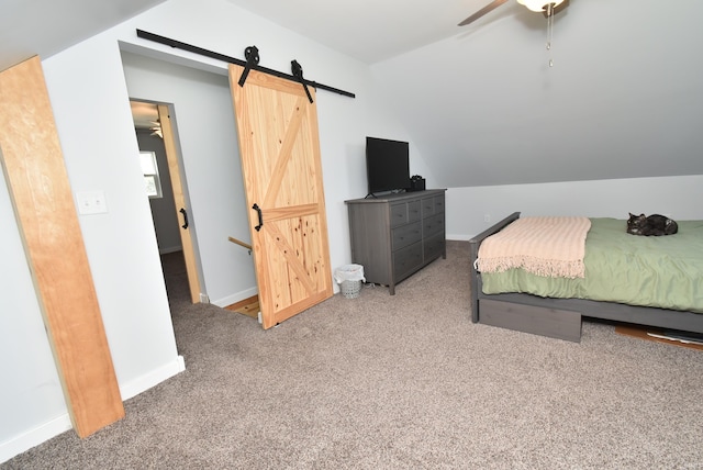 carpeted bedroom featuring a barn door, lofted ceiling, baseboards, and a ceiling fan