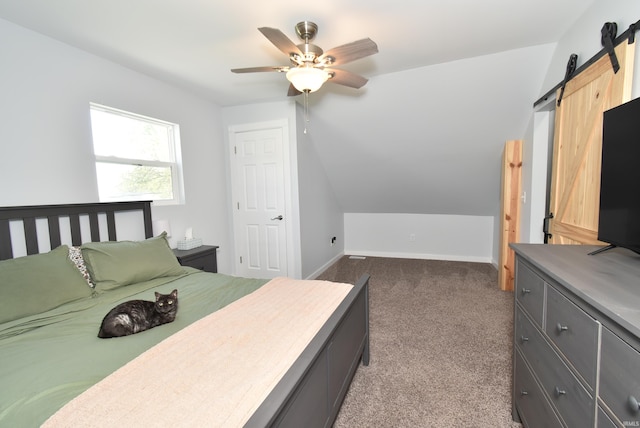 carpeted bedroom featuring ceiling fan, baseboards, vaulted ceiling, and a barn door