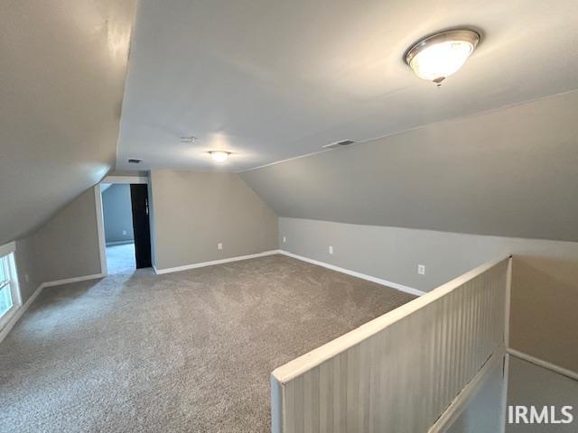 1023 W Franklin St, Evansville, IN 47710 - bonus room with lofted ceiling, baseboards, and carpet
