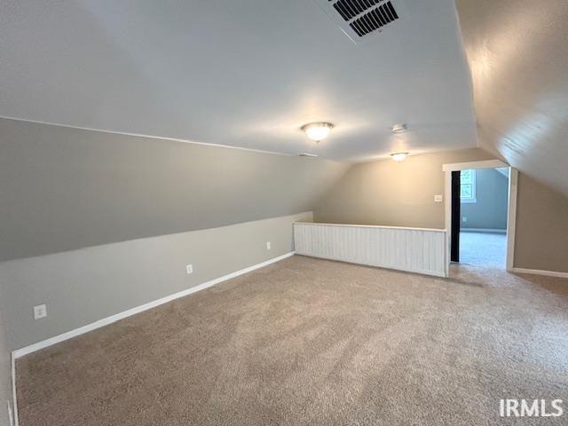 1023 W Franklin St, Evansville, IN 47710 - additional living space with lofted ceiling, carpet flooring, and baseboards