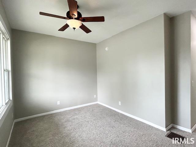 1023 W Franklin St, Evansville, IN 47710 - empty room with a ceiling fan, carpet flooring, and baseboards