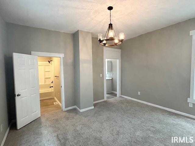 1023 W Franklin St, Evansville, IN 47710 - empty room featuring a chandelier, carpet, and baseboards