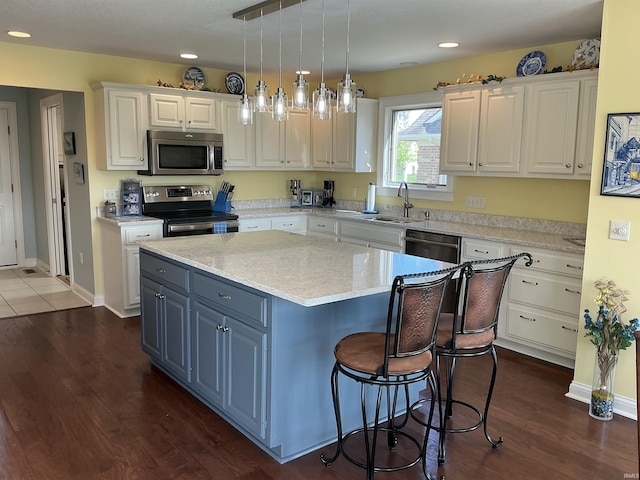 12217 Harvest Bay Dr, Fort Wayne, IN 46845 - kitchen featuring stainless steel appliances, white cabinetry, a center island, a sink, and dark wood-type flooring