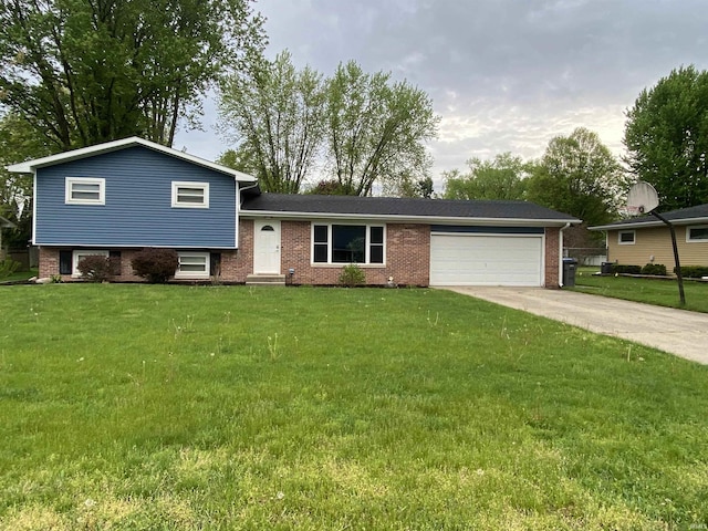 split level home with a garage, concrete driveway, a front lawn, and brick siding