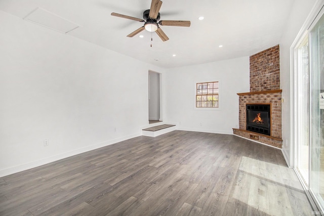 unfurnished living room featuring wood finished floors, ceiling fan, a fireplace, recessed lighting, and baseboards