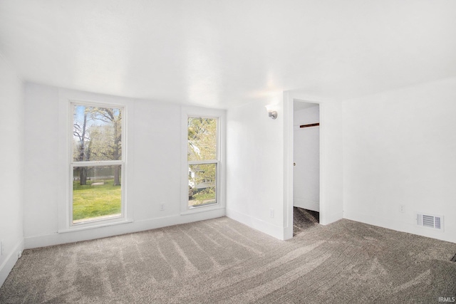 empty room featuring carpet flooring, plenty of natural light, and baseboards