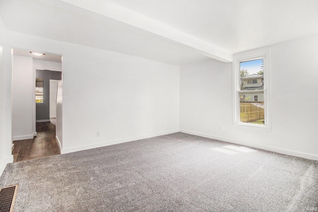 empty room featuring carpet flooring and baseboards