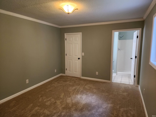 carpeted empty room featuring ornamental molding, baseboards, and a textured ceiling
