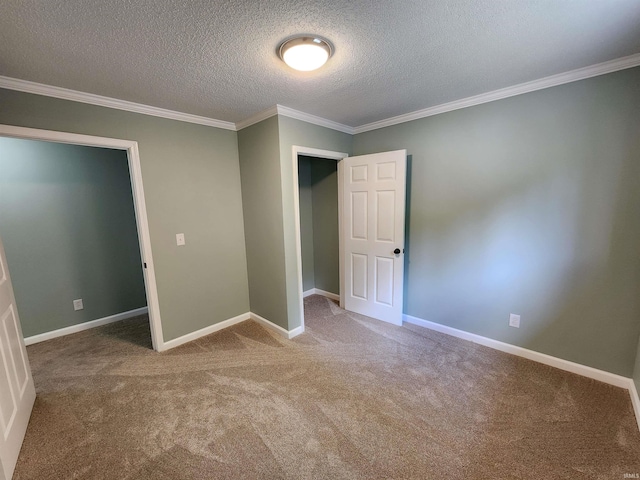 unfurnished bedroom with carpet flooring, a textured ceiling, crown molding, and baseboards