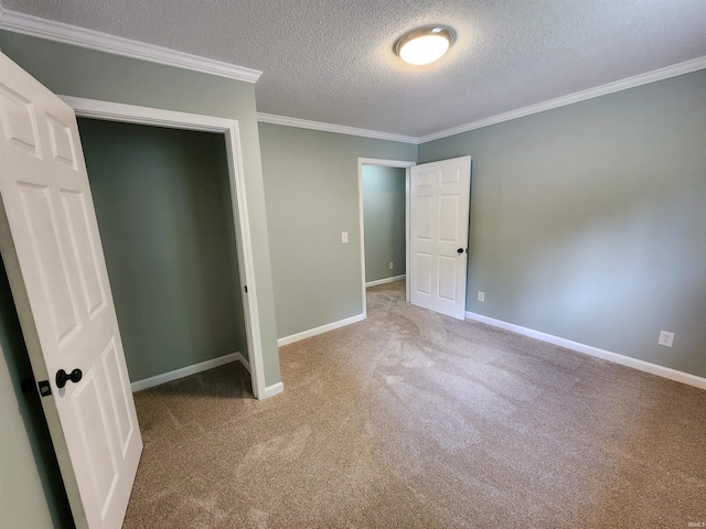 unfurnished bedroom featuring carpet flooring, a textured ceiling, crown molding, and baseboards