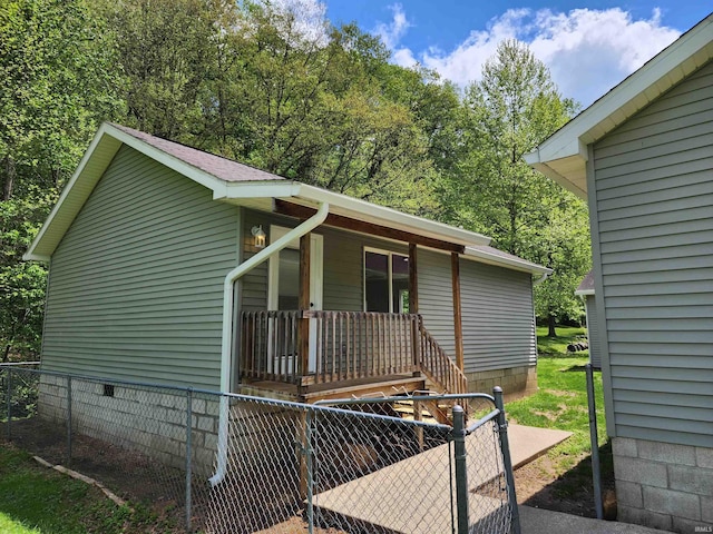 view of side of home with a porch and fence