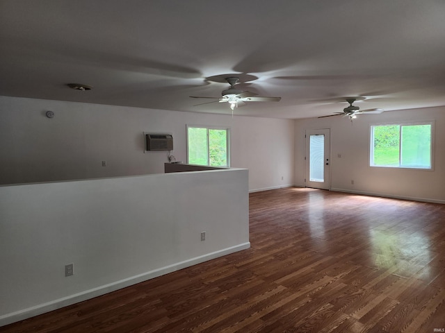 unfurnished room featuring plenty of natural light, dark wood-type flooring, and baseboards