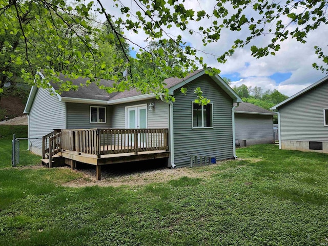 rear view of property with a wooden deck and a lawn
