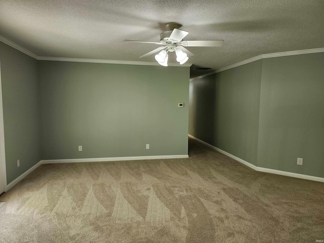 empty room with ornamental molding, a textured ceiling, carpet floors, ceiling fan, and baseboards