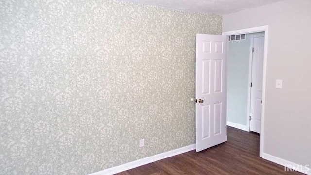 unfurnished room featuring wood finished floors and baseboards