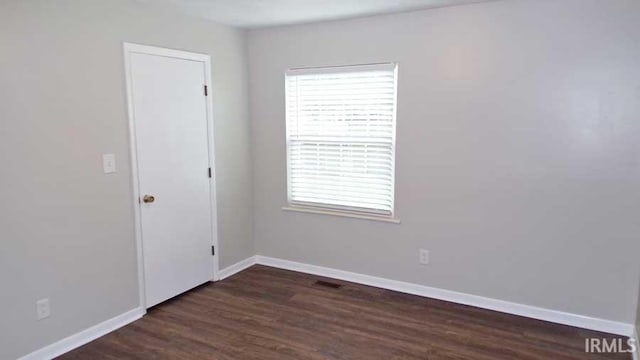 unfurnished room with dark wood-style flooring and baseboards