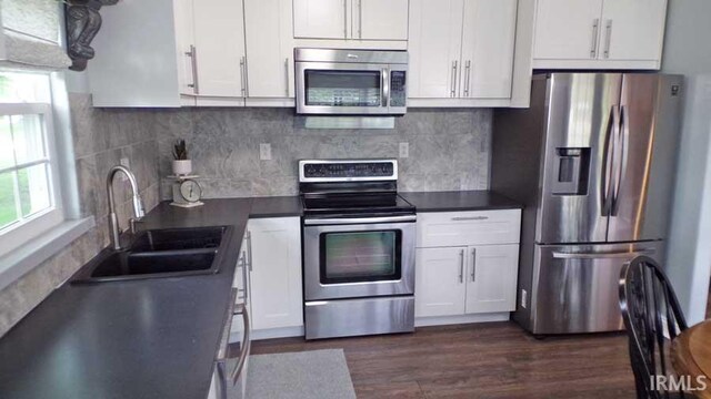 kitchen featuring appliances with stainless steel finishes, a sink, and white cabinets