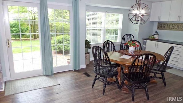 dining space with wood finished floors and a chandelier