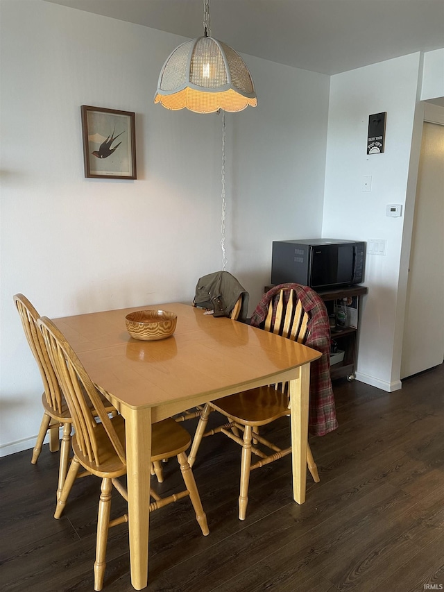 dining room featuring wood finished floors and baseboards