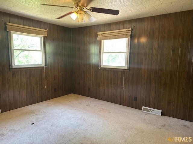 108 S Main St, Patoka, IN 47666 - carpeted spare room featuring healthy amount of natural light, wooden walls, and ceiling fan