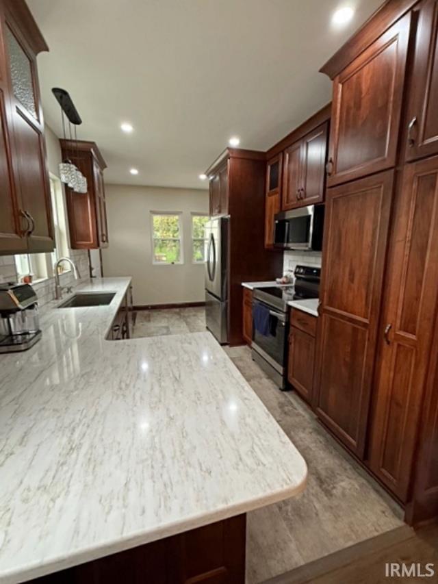 110 W Elnora St, Odon, IN 47562 - kitchen with stainless steel appliances, a sink, recessed lighting, light wood-style floors, and decorative backsplash