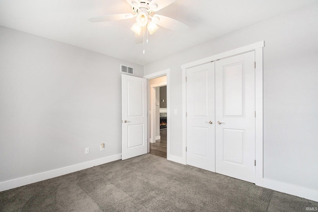 unfurnished bedroom with carpet flooring, baseboards, a closet, and ceiling fan