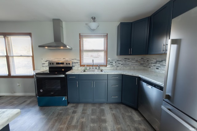 kitchen with wall chimney exhaust hood, stainless steel appliances, a sink, and wood finished floors