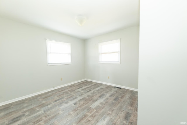 unfurnished room with light wood finished floors and baseboards