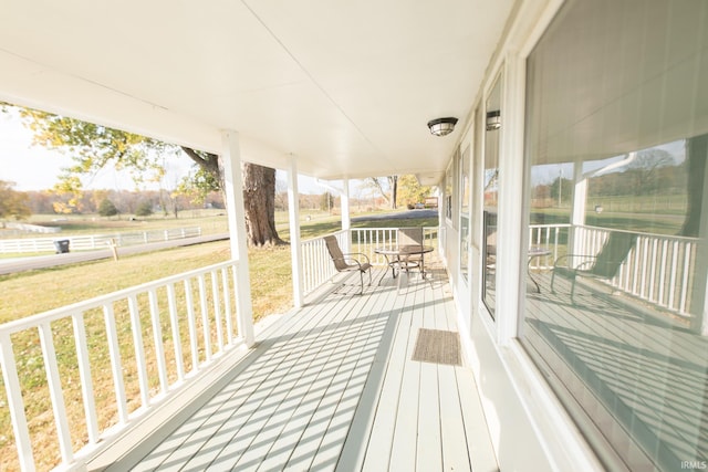 wooden deck with covered porch and a yard