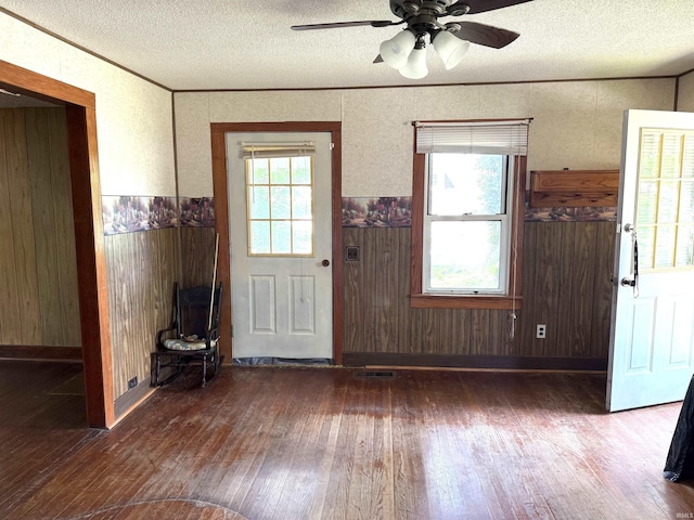 219 W Boone St, Gentryville, IN 47537 - foyer entrance with wood-type flooring, a textured ceiling, ceiling fan, a wainscoted wall, and wood walls