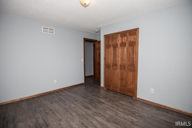 10217 Lake Tahoe Ct, Fort Wayne, IN 46804 - unfurnished bedroom with dark wood-type flooring, baseboards, a textured ceiling, and a closet