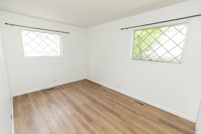 spare room featuring light wood-type flooring and baseboards