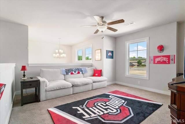 living room with carpet floors, a chandelier, baseboards, and a ceiling fan