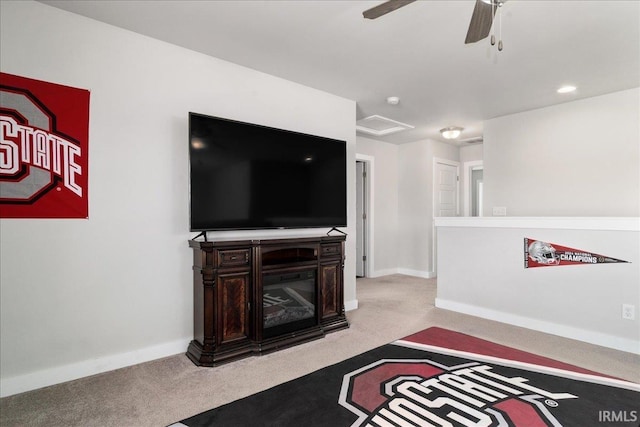 living area featuring carpet flooring, ceiling fan, and baseboards