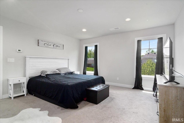 bedroom with light carpet, multiple windows, baseboards, and recessed lighting