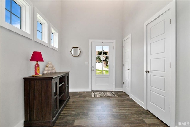 foyer entrance with plenty of natural light, dark wood-style flooring, and baseboards