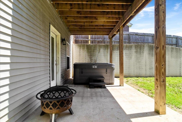 view of patio featuring a hot tub and fence