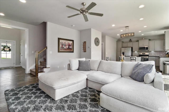 living room featuring dark wood-style floors, recessed lighting, a ceiling fan, stairs, and baseboards
